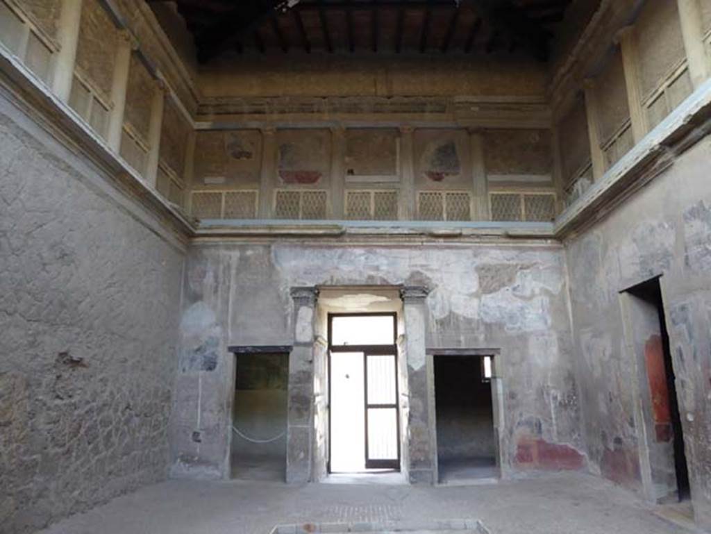 V.1, Herculaneum, October 2014. Looking west in atrium. West wall of atrium, with doorways to room 3, on left, the entrance corridor and room 2, on right.  The upper floor is decorated as a false loggia.  Photo courtesy of Michael Binns.